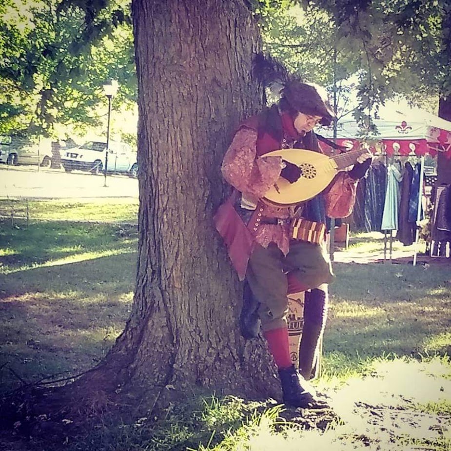 Lutenist leaning against a tree